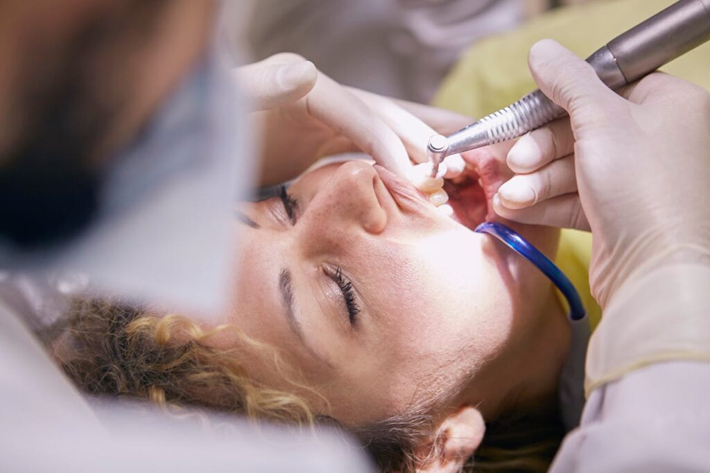 Woman's Teeth Being Clean By Dentist